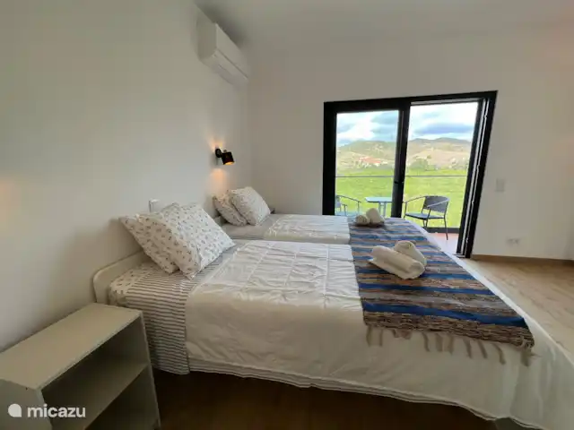 Slaapkamer met twee eenpersoonsbedden, die een eigen badkamer heeft